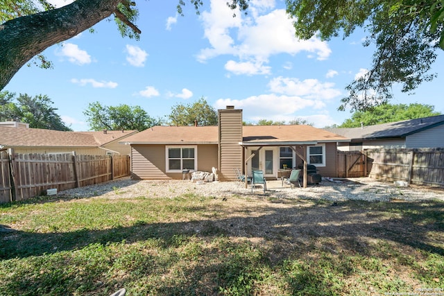 rear view of property featuring a lawn and a patio area