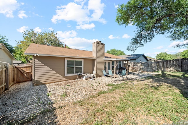 back of house with a lawn and a patio area