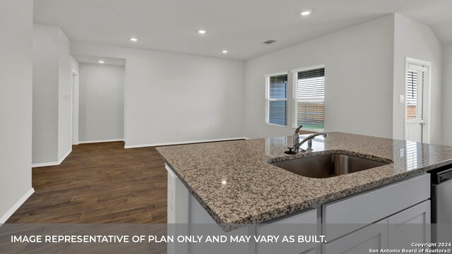 kitchen with dark hardwood / wood-style flooring, light stone counters, a healthy amount of sunlight, and sink