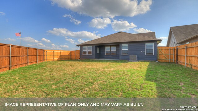 rear view of house with a lawn and cooling unit