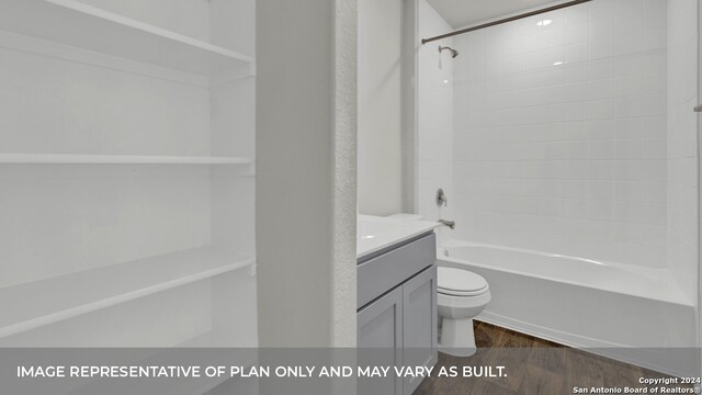 full bathroom featuring hardwood / wood-style floors, tiled shower / bath combo, toilet, and vanity