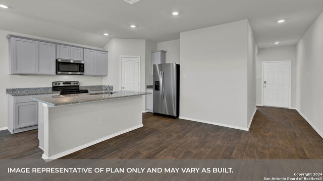 kitchen with light stone counters, gray cabinetry, stainless steel appliances, a center island with sink, and dark hardwood / wood-style flooring