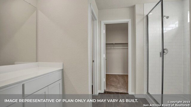 bathroom with vanity, a shower with door, and hardwood / wood-style flooring