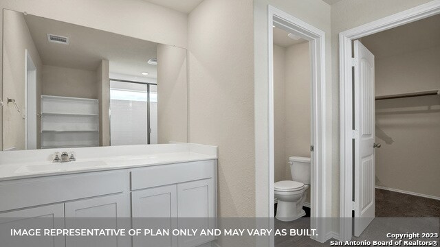 bathroom featuring vanity, toilet, and an enclosed shower