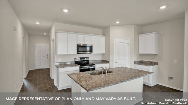 kitchen featuring an island with sink, sink, white cabinetry, stainless steel appliances, and dark hardwood / wood-style floors