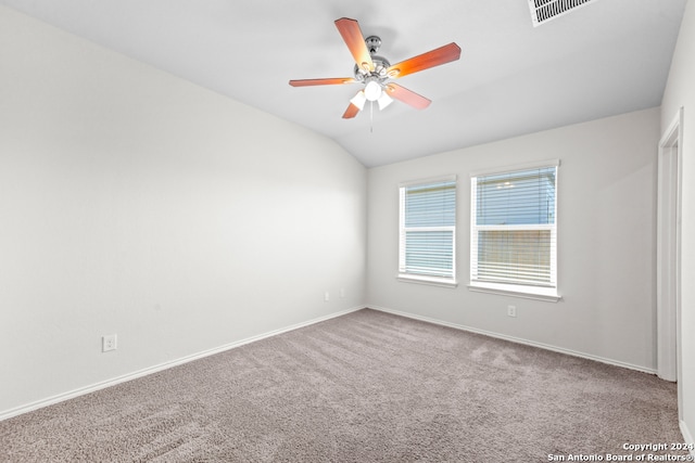 carpeted spare room with ceiling fan and vaulted ceiling