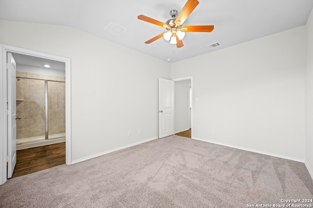 unfurnished bedroom featuring lofted ceiling, carpet, ceiling fan, and ensuite bath