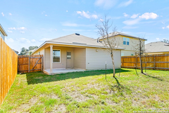 back of house with a lawn and a patio area