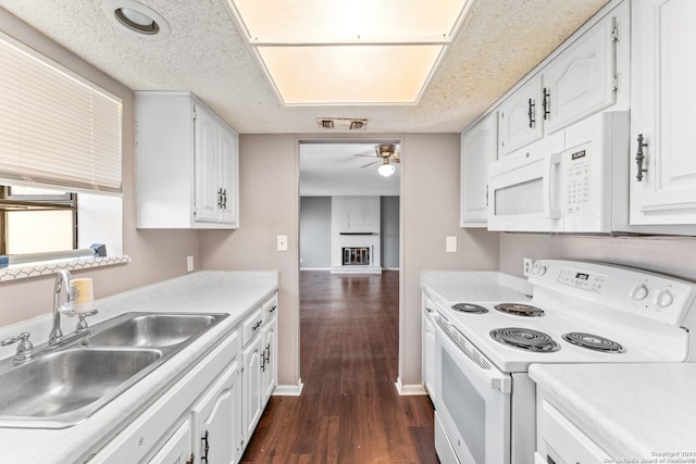 kitchen with white cabinetry, white appliances, ceiling fan, dark hardwood / wood-style floors, and sink