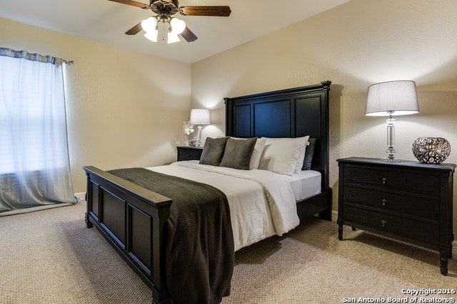 bedroom with ceiling fan and light colored carpet