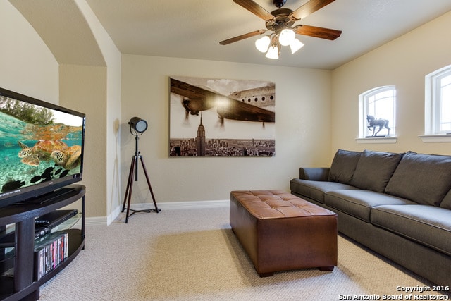 carpeted living room featuring ceiling fan