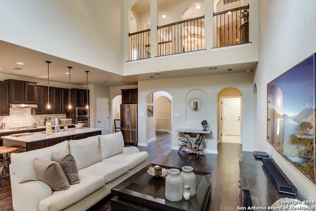 living room with dark wood-type flooring and a high ceiling