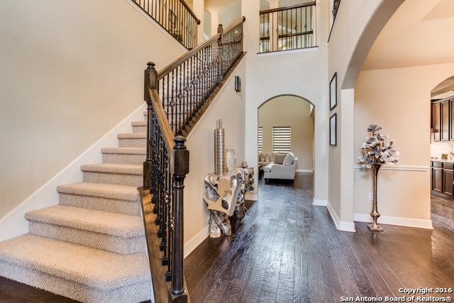 foyer entrance featuring a towering ceiling and dark hardwood / wood-style floors