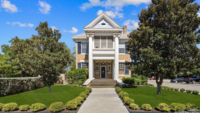 greek revival inspired property with a front yard