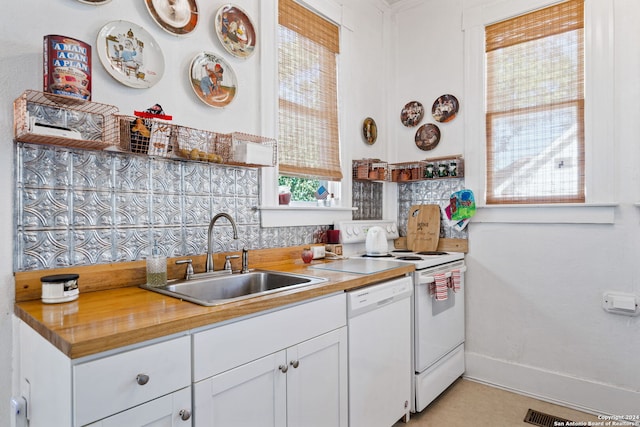 kitchen with white cabinets, white dishwasher, plenty of natural light, and sink