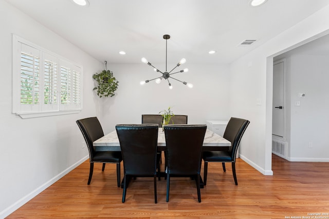 dining area featuring a notable chandelier and light hardwood / wood-style floors