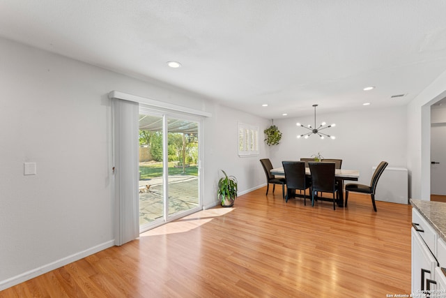 dining room featuring light wood-type flooring and a notable chandelier