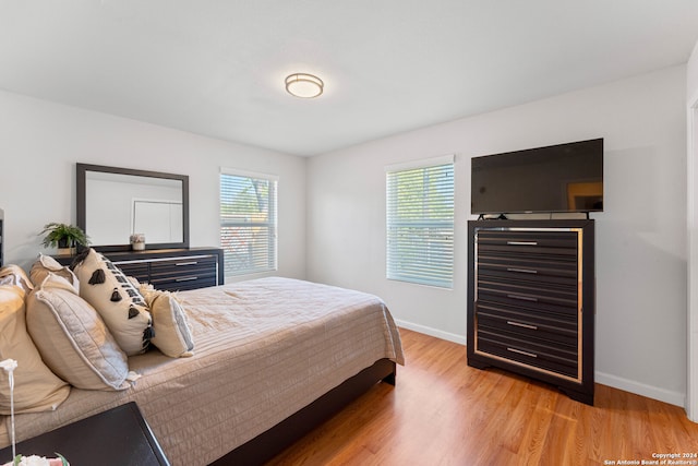 bedroom featuring light hardwood / wood-style flooring and multiple windows