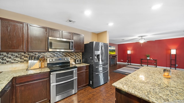 kitchen with light stone countertops, dark brown cabinetry, dark hardwood / wood-style floors, tasteful backsplash, and appliances with stainless steel finishes