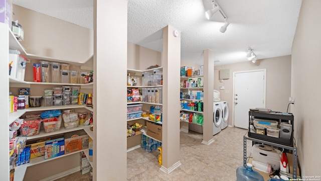 laundry room with separate washer and dryer, rail lighting, and a textured ceiling