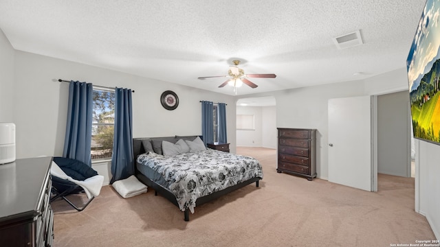 carpeted bedroom with ceiling fan and a textured ceiling