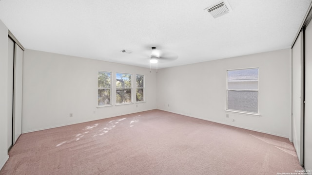 unfurnished bedroom with ceiling fan and light colored carpet