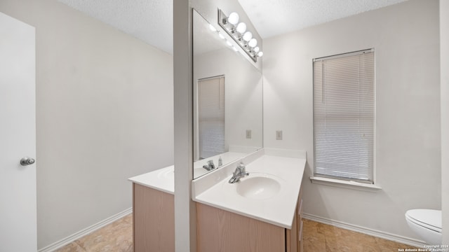 bathroom featuring a textured ceiling, tile patterned flooring, vanity, and toilet