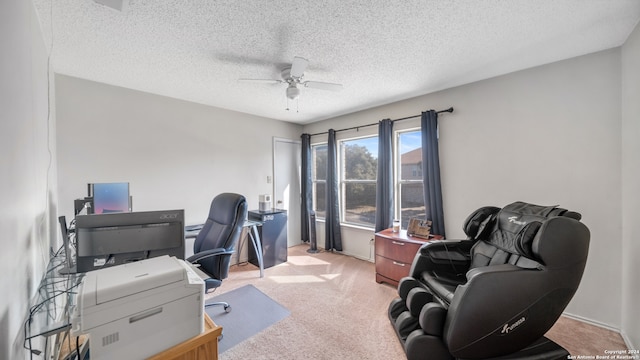 carpeted home office featuring a textured ceiling and ceiling fan