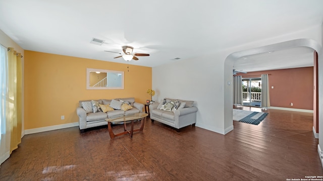 living room with ceiling fan and dark hardwood / wood-style flooring