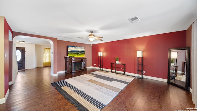 living room with a fireplace, dark hardwood / wood-style floors, and ceiling fan