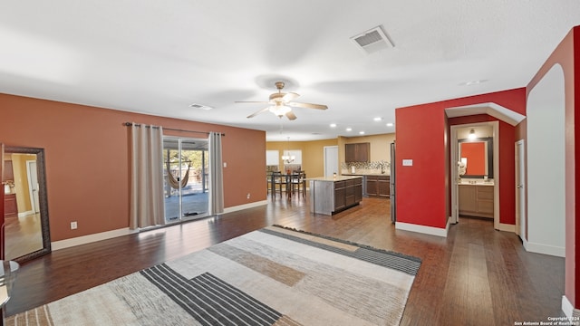 living room with ceiling fan and dark wood-type flooring