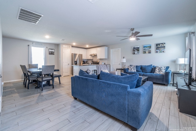 living room with ceiling fan and light hardwood / wood-style flooring