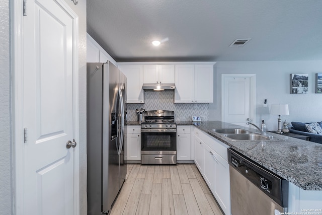 kitchen featuring stainless steel appliances, white cabinetry, tasteful backsplash, and sink