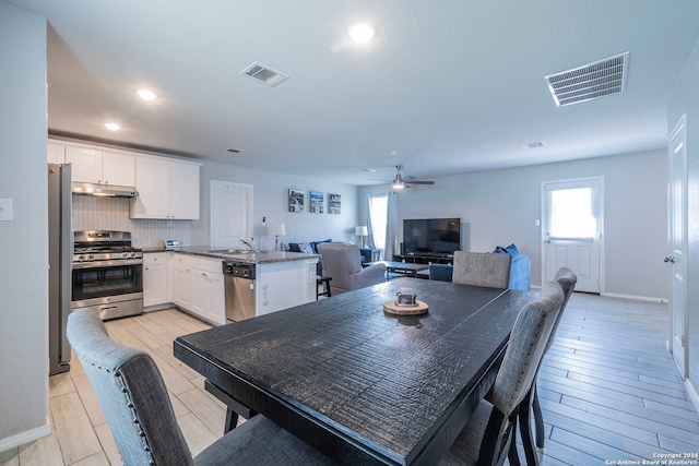 dining area with light hardwood / wood-style floors and ceiling fan