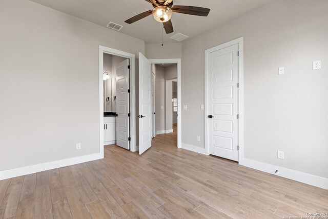 unfurnished bedroom featuring ceiling fan, light hardwood / wood-style floors, and connected bathroom