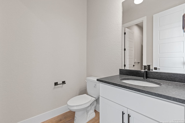 bathroom with hardwood / wood-style floors, vanity, and toilet