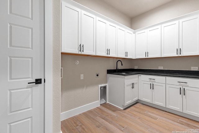 laundry room featuring cabinets, light hardwood / wood-style floors, hookup for an electric dryer, and sink