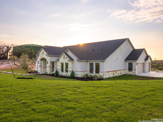 view of front of home featuring a lawn and a garage