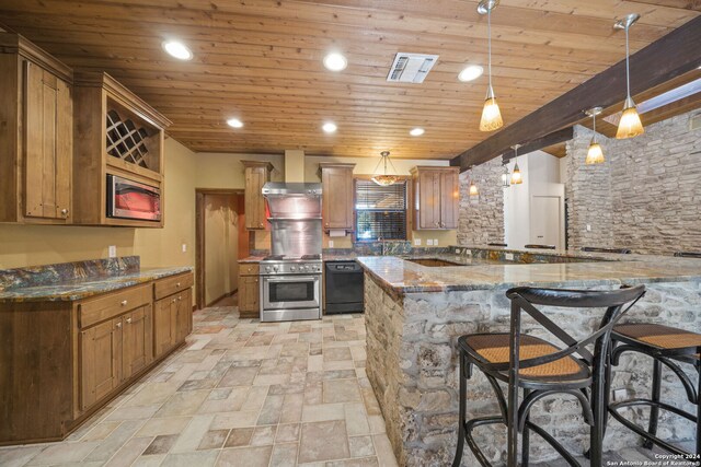 kitchen with pendant lighting, dishwasher, wall chimney range hood, high end range, and stone countertops