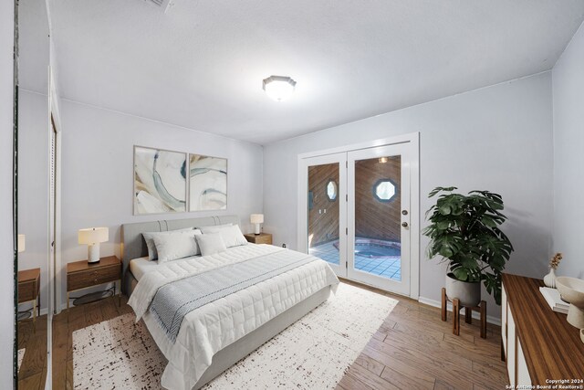 bedroom featuring french doors, access to exterior, and hardwood / wood-style floors