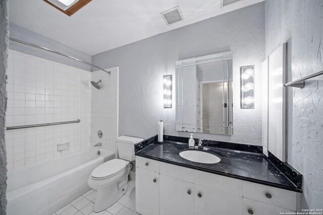 full bathroom featuring vanity, tiled shower / bath combo, toilet, and tile patterned flooring