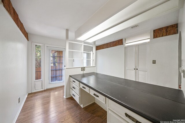 kitchen with dark wood-type flooring and white cabinets