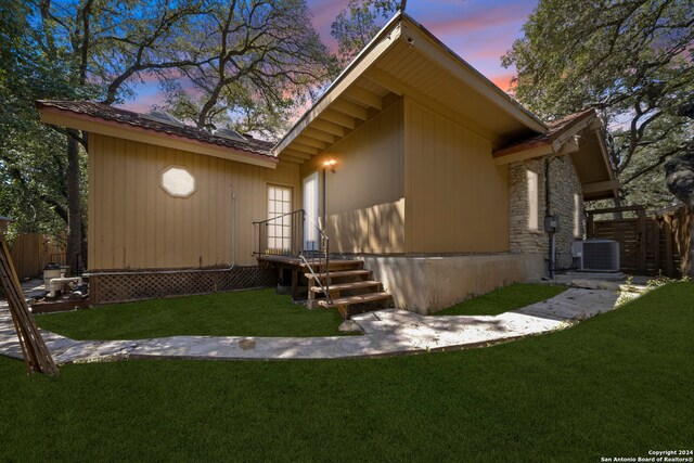 exterior space with cooling unit and a yard