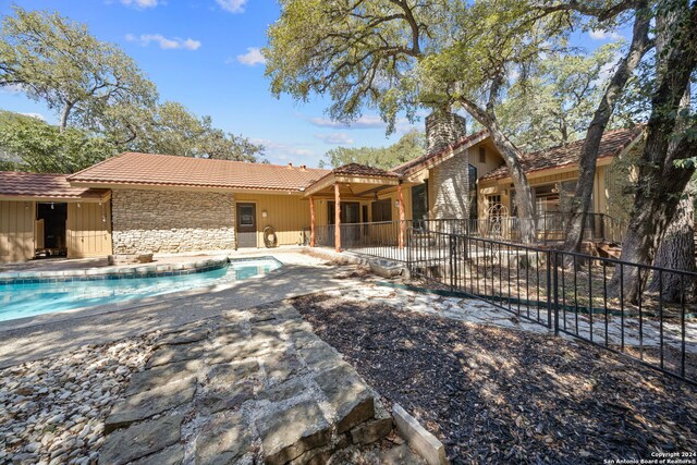 back of property with a fenced in pool and a patio area