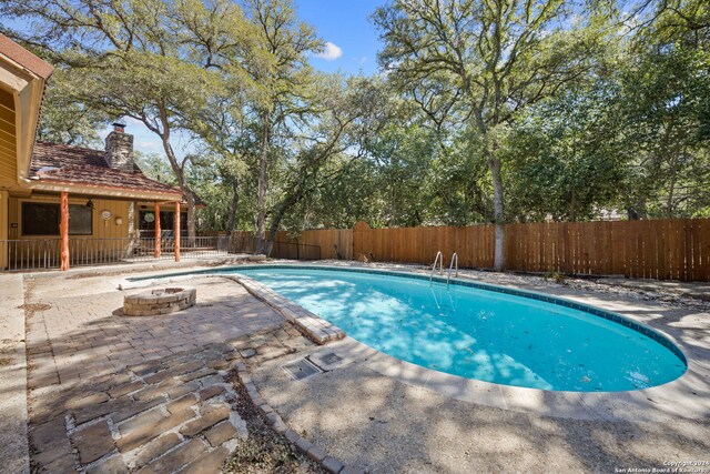 view of pool with a patio and a fire pit