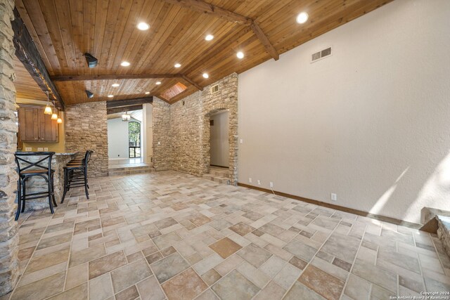 unfurnished living room featuring beamed ceiling, indoor bar, high vaulted ceiling, and wooden ceiling