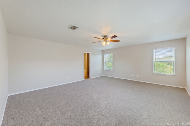 carpeted spare room featuring ceiling fan