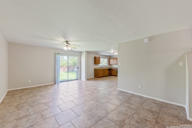 unfurnished living room featuring light tile patterned floors and ceiling fan