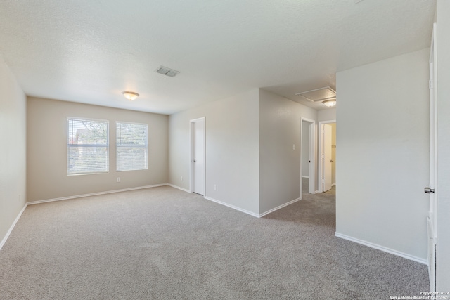 carpeted empty room with a textured ceiling