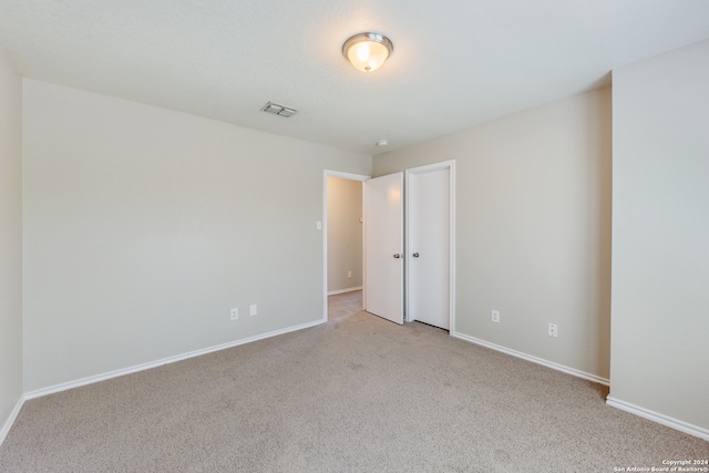 unfurnished room featuring light colored carpet